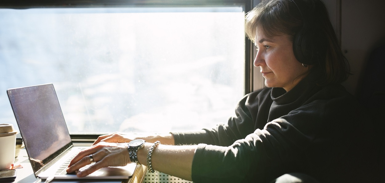 Kvinna arbetar vid en dator ombord på ett tåg